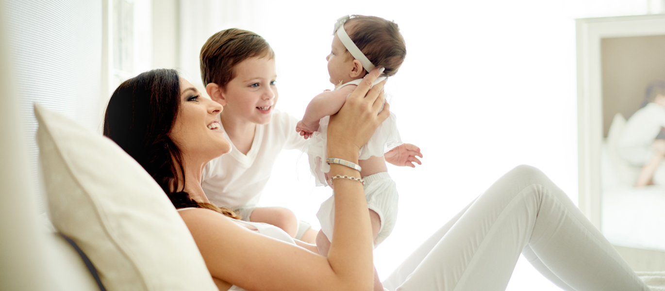 A mother with newborn and younger child