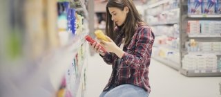 Woman choosing sunscreen lotion