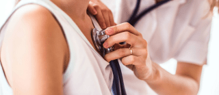 Doctor using Stethoscope on young patient