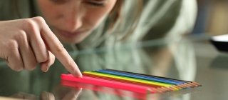 Person aligning up pencils on a table