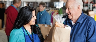 Man picking up food from food shelf 