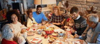 family and friends sitting at a table for a holiday dinner