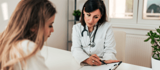 Doctor and patient sitting at a table going over test results 