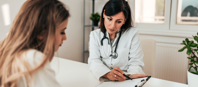 Doctor and patient sitting at a table going over test results 